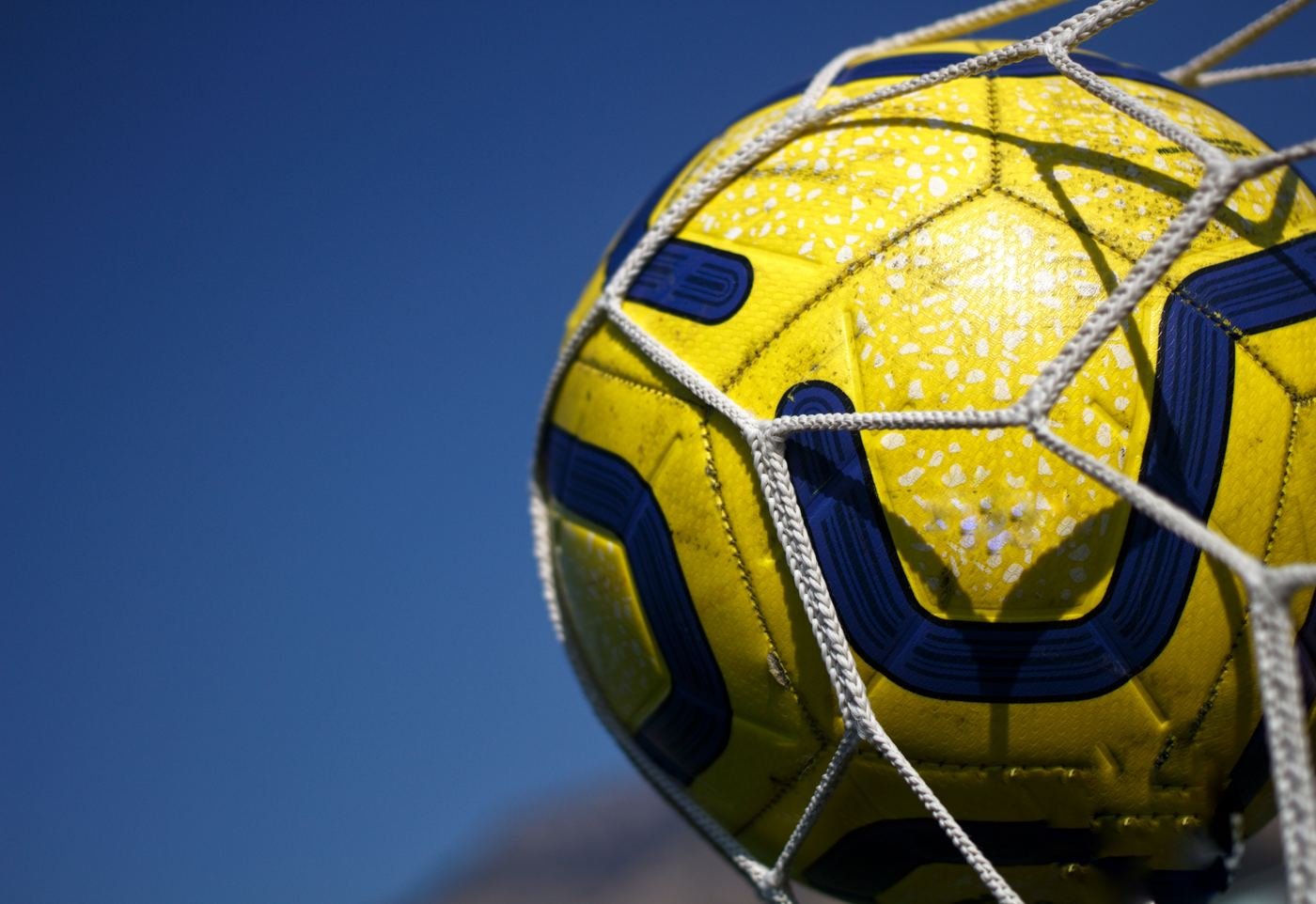 A football hitting the back of the net